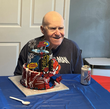 Alan smiles behind his Spider-Man cake