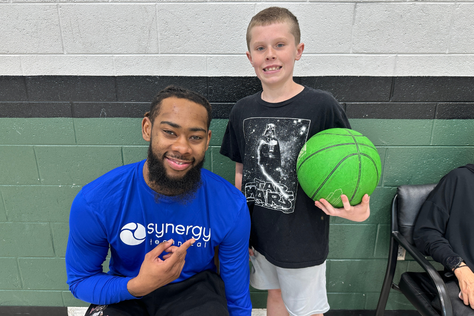 Synergy staff smile with a Minnick student