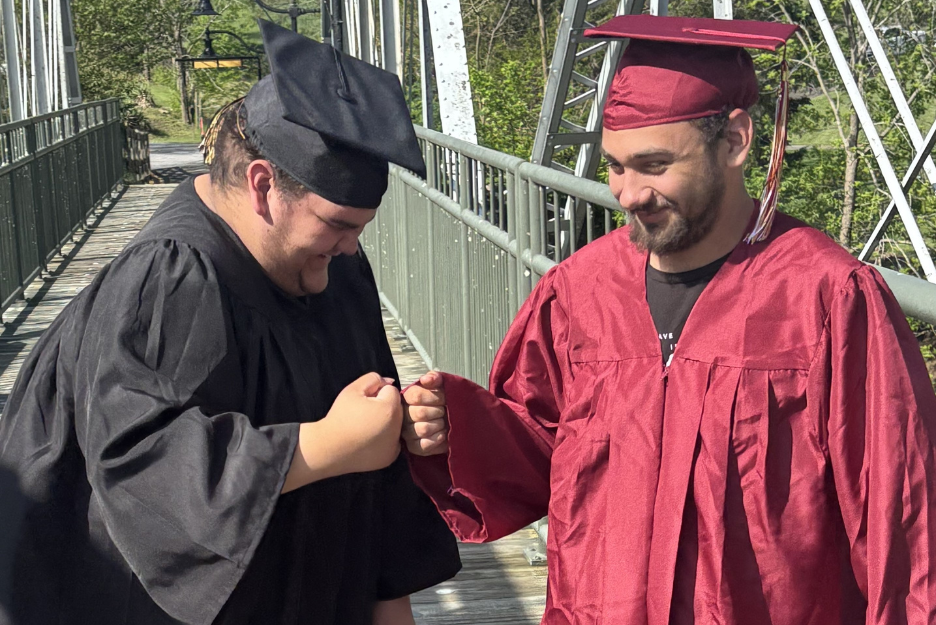 Shawn and Cody smile in their cap and gowns