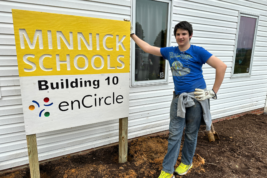 A student poses with the Minnick Schools Building 10 sign