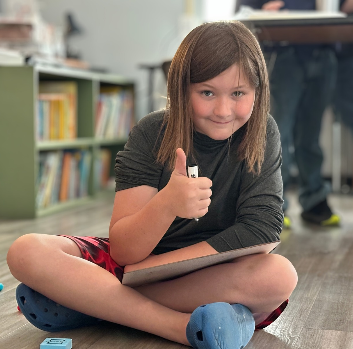 A student gives a thumbs up at the camera