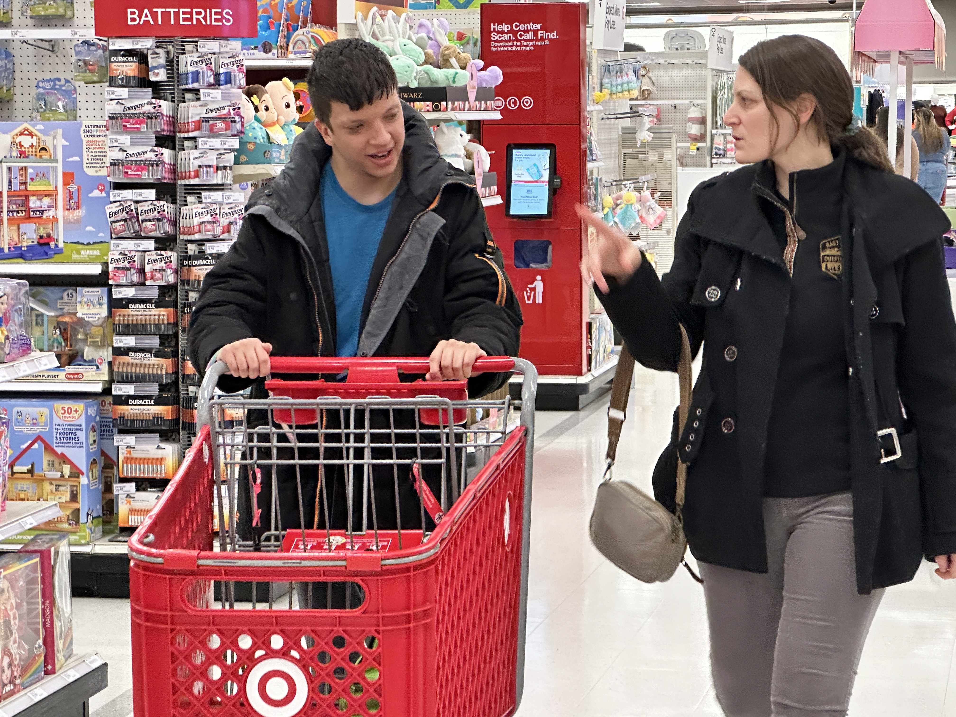 Hunter pushes a cart in Target while Alyson walks beside him