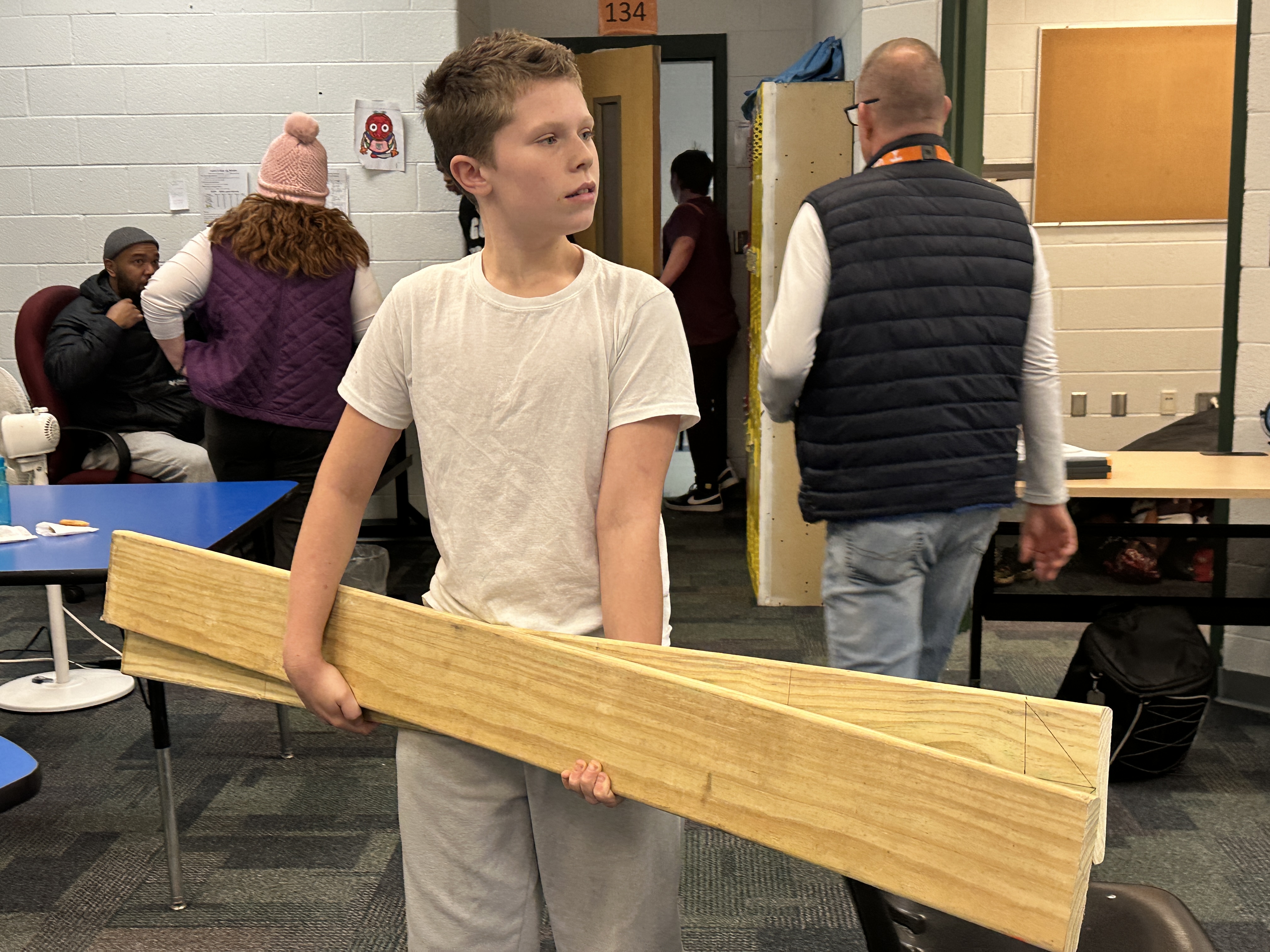 Shaun carries wood in the classroom