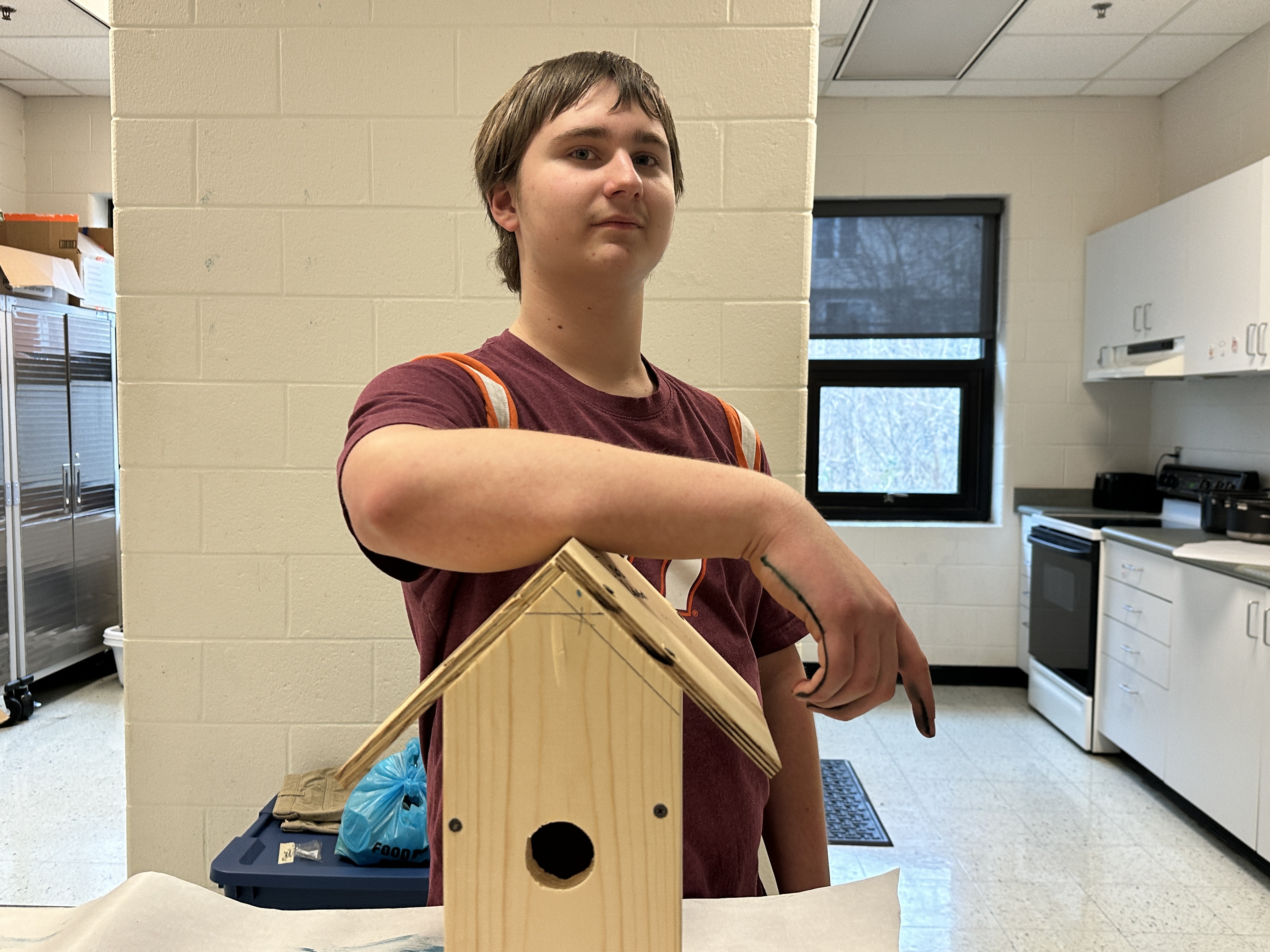 Cody stands with his birdhouse