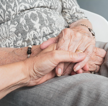 A younger hand holds an older hand