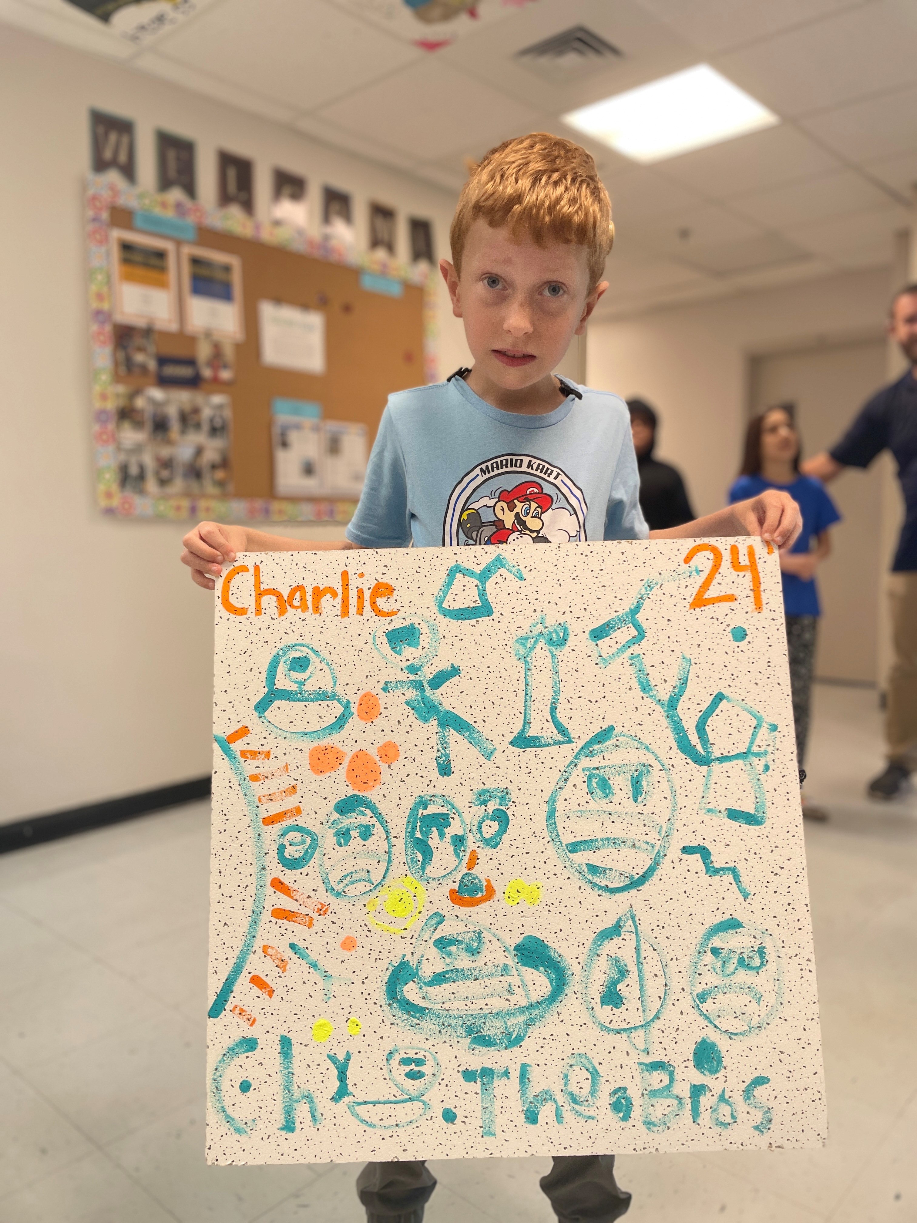 A Harrisonburg student holds up his ceiling tile