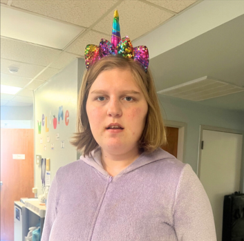 Kaylee stands with a unicorn headband on