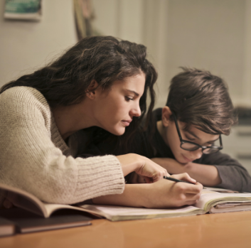 An adult helps a student with school work