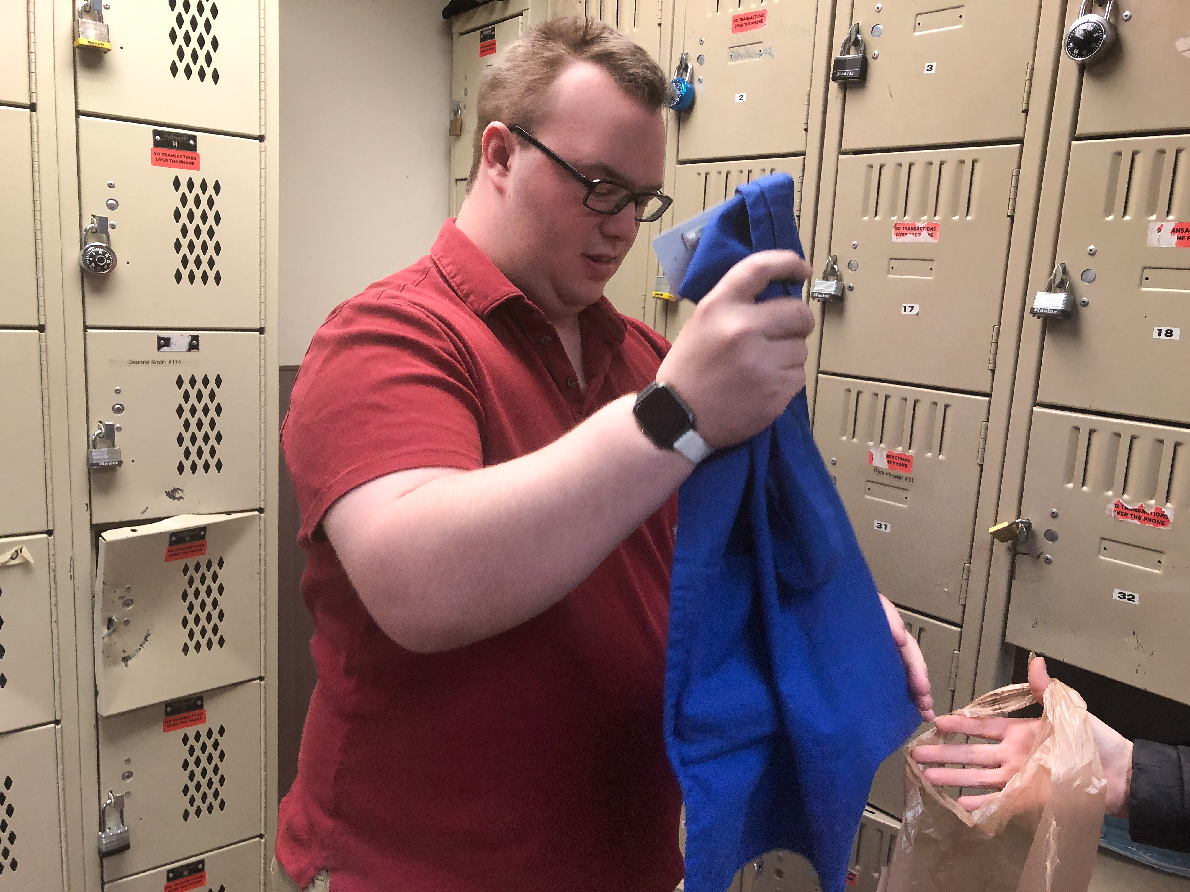 Ben puts his apron away in a locker room