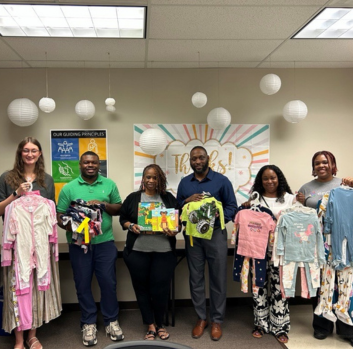 Regina and staff of enCircle's Treatment Foster Care team stand together with clothing and donations from Regina.
