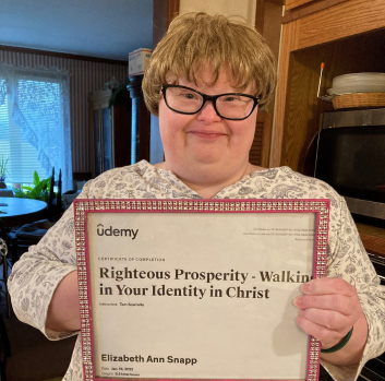 Elizabeth holds her certificate 