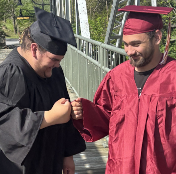 Two graduates smile and fist-bump