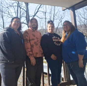 West Virginia Staff smile at the camera from the porch of a Group Home