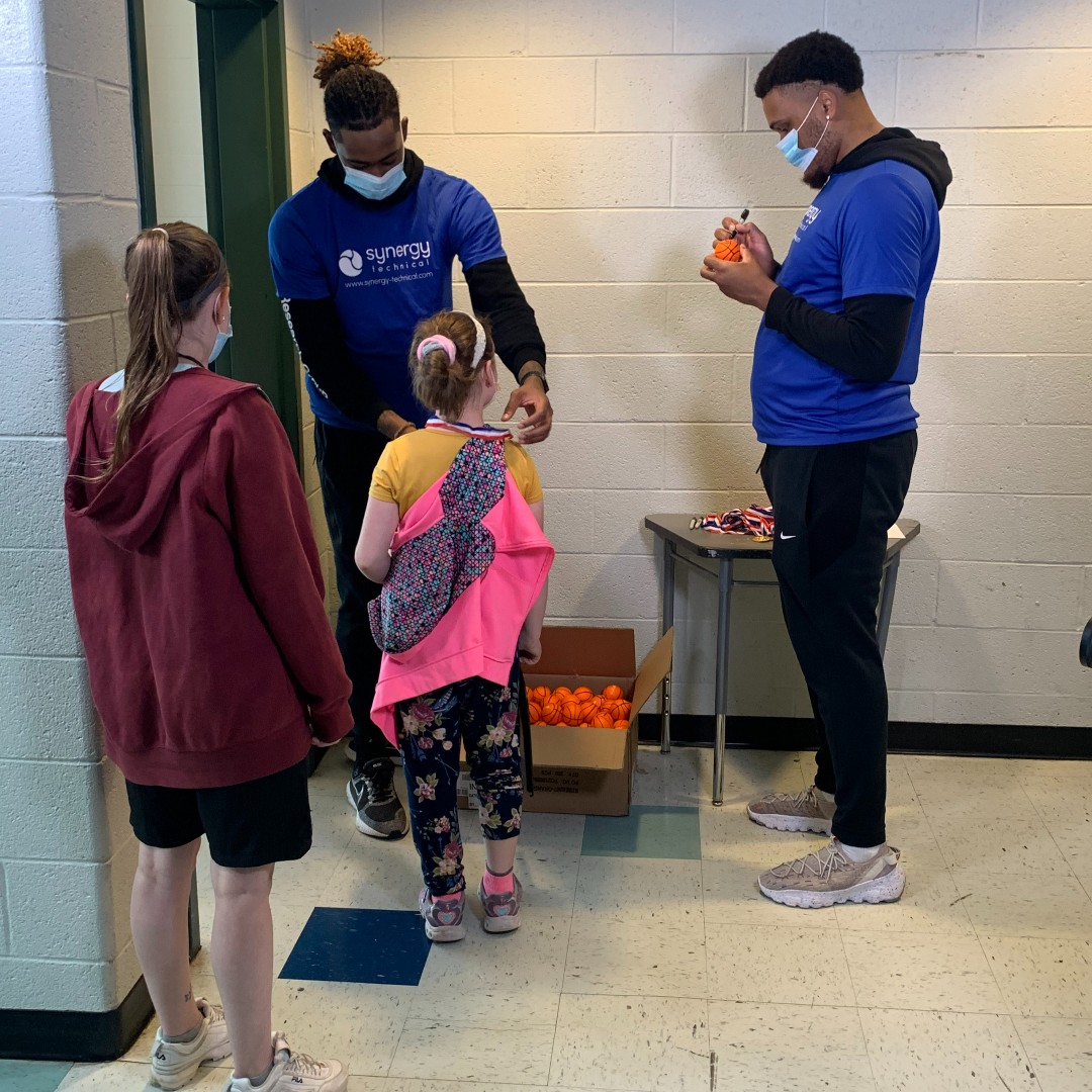 Mikeal and Levi sign small basketballs for Minnick students