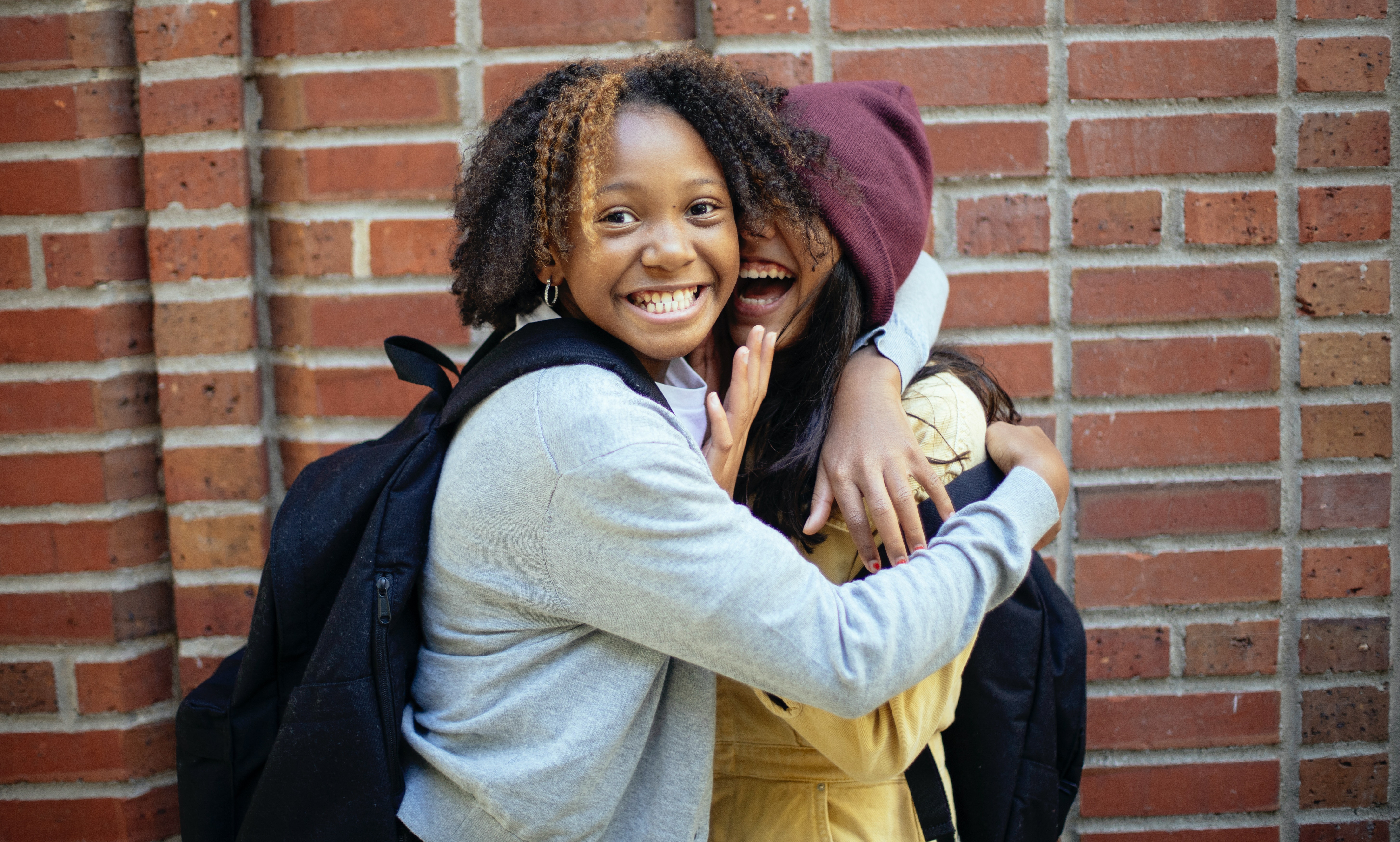 Two students hugging and smiling