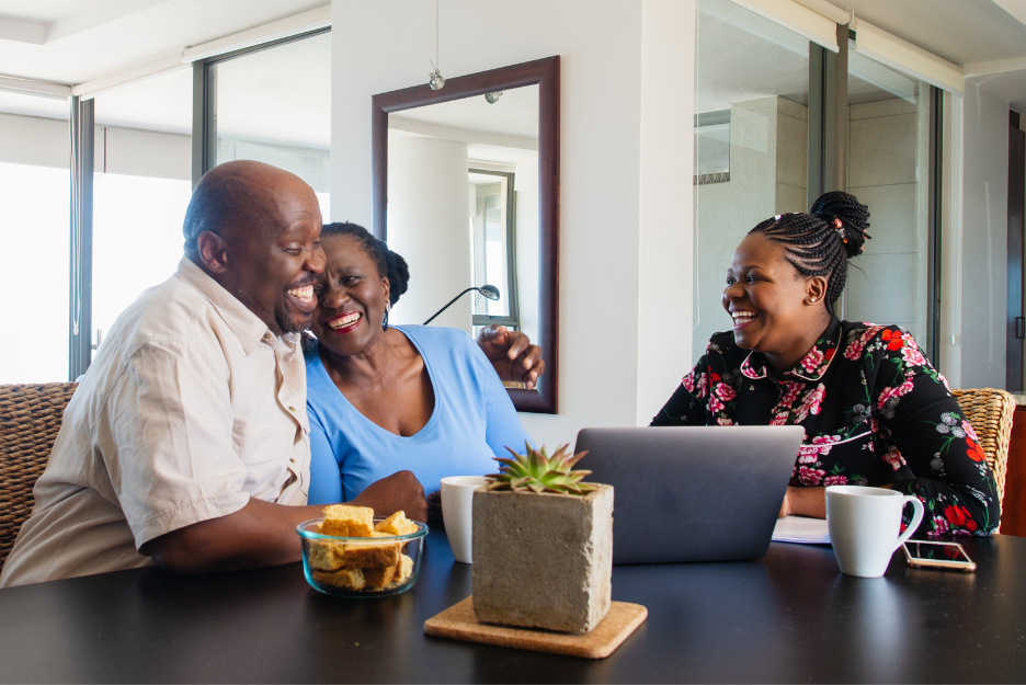 A couple smiles and embraces at a table with an accountant