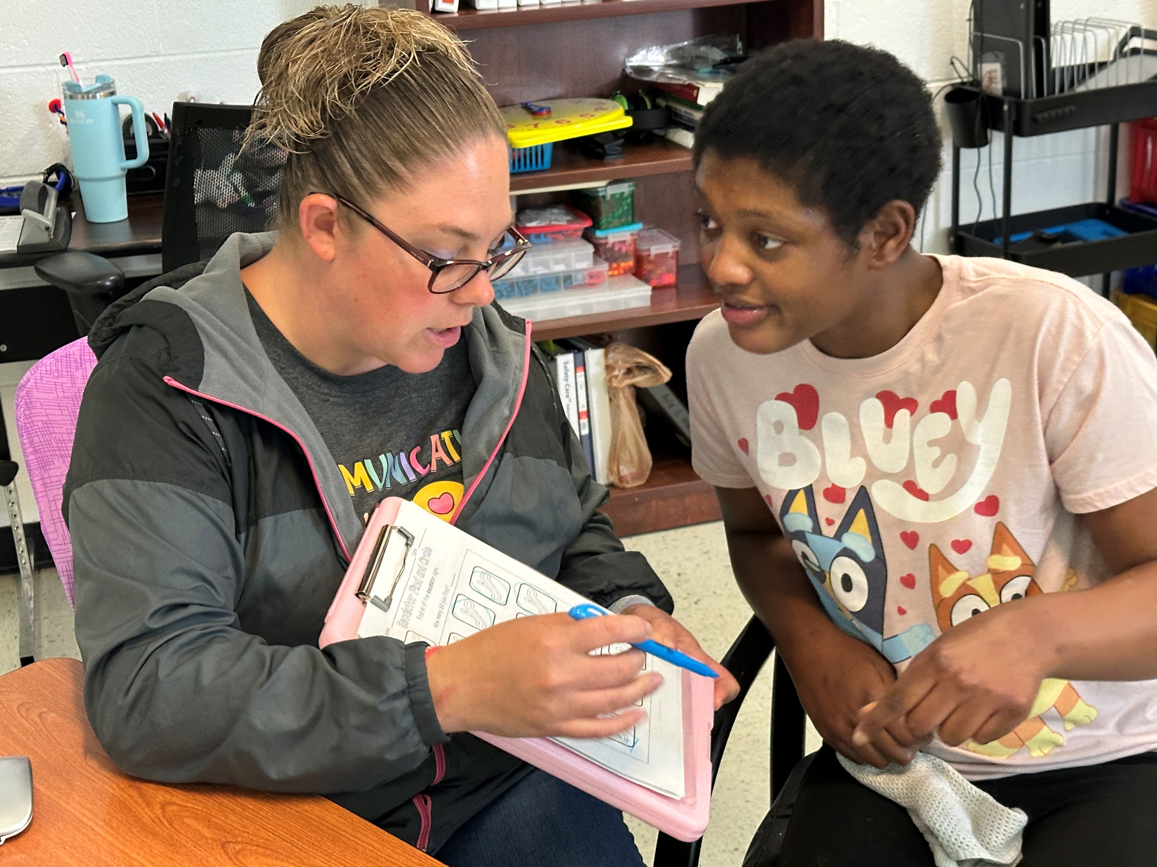 A teacher works with a student
