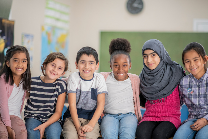 Children of different ethnicities smile at the camera