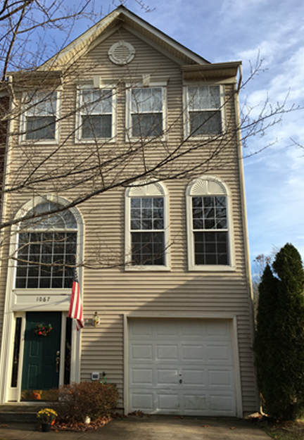 An end unit tan town home with a one car garage